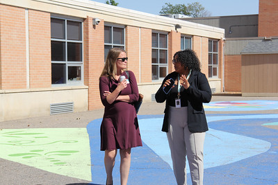 Two female educators talking outside of a school building