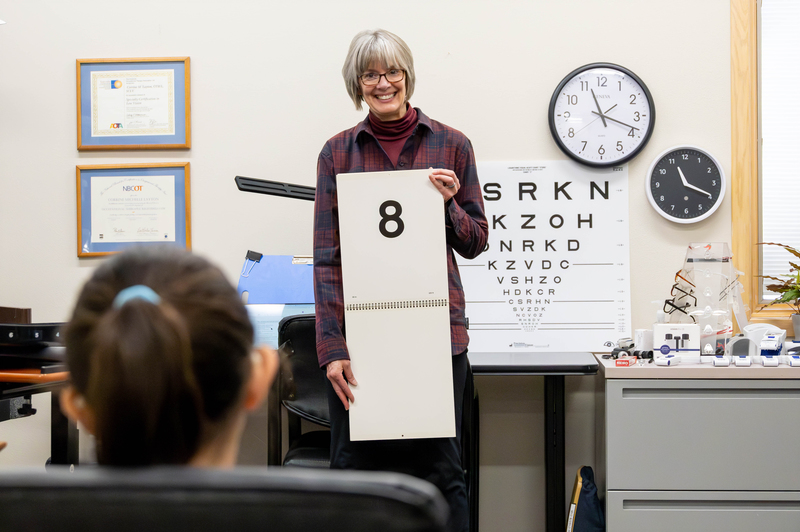 A woman holds up a card with the number 8.