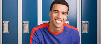 Young man smiling in front of lockers at school