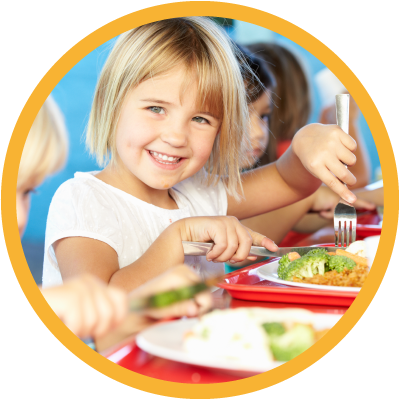 Young child smiling and eating lunch